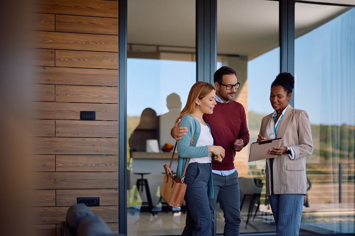 A real estate agent reviewing housing plans with a couple buying a new home